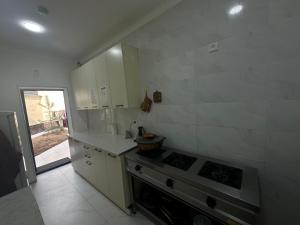 a kitchen with white cabinets and a stove in it at Hostel Mevazor in Katartal