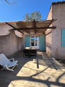 a patio with a table and a chair and a table at Résidence Les Cigales in Porto-Vecchio