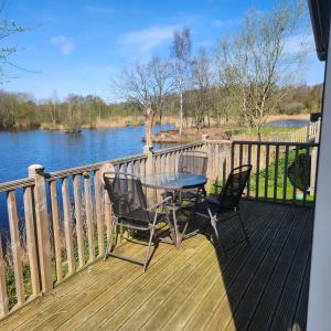 a table and chairs on a deck with a view of a river at 10 Sunset view in Scunthorpe