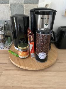 eine Kaffeemaschine auf einem Holzschneidebrett mit Gewürzen in der Unterkunft Appartement l'Ecrin 2 in Saint-Claude + 17 Fotos