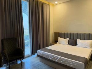 a bedroom with a bed and a chair and a window at Jawla Resort in Palwal