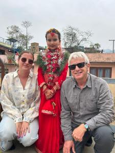 a woman in a red dress sitting between two people at Season homestay in Kathmandu +8 photos