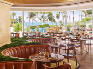a restaurant with tables and chairs and a view of the ocean at Faena Miami Beach in Miami Beach