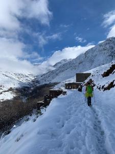 two people walking up a snow covered mountain at Atlas Imsker in Marrakesh