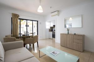 a living room with a couch and a table at Mouraliz Apartments by HD PROPERTIES - Vilamoura Marina in Vilamoura
