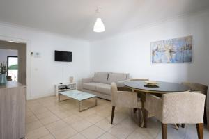 a living room with a table and a couch at Mouraliz Apartments by HD PROPERTIES - Vilamoura Marina in Vilamoura