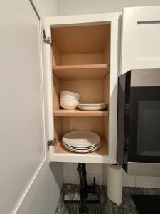a cabinet with plates and bowls in it at Cozy Modern Studio in Philadelphia