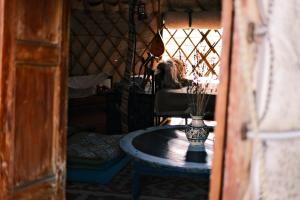 a room with a table and a chair with a vase on it at Nomad Yurt, 60 year old in Ryskulovo
