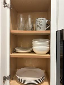 a cupboard with plates and bowls and a coffee mug at Cozy Modern Studio in Philadelphia +28 photos