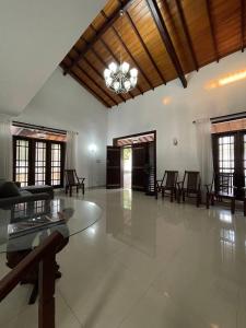 a large living room with a glass table and chairs at Mayon's Home in Kalutara