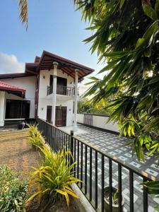 a house with a fence in front of it at Mayon's Home in Kalutara