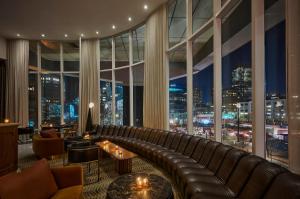 a living room with a leather couch and a large window at ModernHaus SoHo in New York