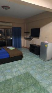 a hotel room with a bed and a flat screen tv at Redbull guest house in Pattaya