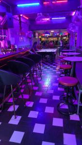 a room with tables and chairs and purple lights at Redbull guest house in Pattaya