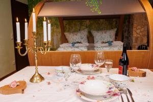 a table with plates and glasses and a bed at BioNestlein Premium Apartments mit Biosauna, Wintergarten & exklusiver Bio-Verpflegung in Löffingen +29 photos