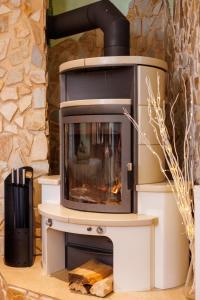 a fireplace in a living room with a stone wall at BioNestlein Premium Apartments mit Biosauna, Wintergarten & exklusiver Bio-Verpflegung in Löffingen