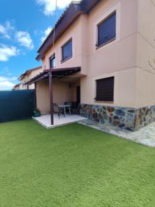 a house with a green lawn in front of it at Casa any in Segovia