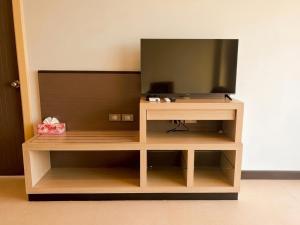 a wooden entertainment center with a television on it at Satun Le Grand - โรงแรม สตูล เลอแกรนด์ in Ban To La Nua