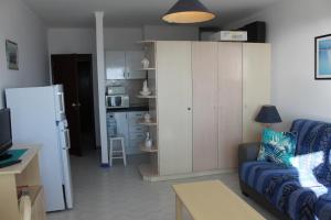 a living room with a couch and a kitchen at Praia Rocha Balcony First Line Beach View Studio in Praia da Rocha
