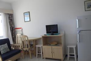 a living room with a small table and a tv at Praia Rocha Balcony First Line Beach View Studio in Praia da Rocha