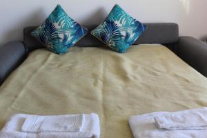 a bed with two pillows on top of it at Praia Rocha Balcony First Line Beach View Studio in Praia da Rocha