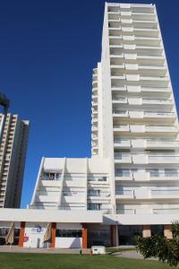 a large white building with two tall buildings at Praia Rocha Balcony First Line Beach View Studio in Praia da Rocha