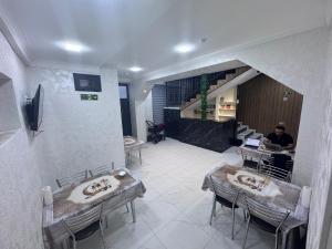 a room with two tables and a man sitting at a desk at Hostel Mevazor in Katartal