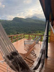 a porch with chairs and a hammock on a deck at Cabana Refúgio da Montanha in Alfredo Wagner +15 photos