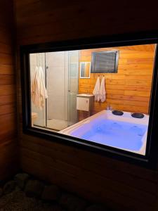 a large blue tub in a bathroom with a shower at Cabana Refúgio da Montanha in Alfredo Wagner