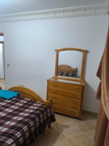 a bedroom with a bed and a dresser with a mirror at nayla y amira in Martil