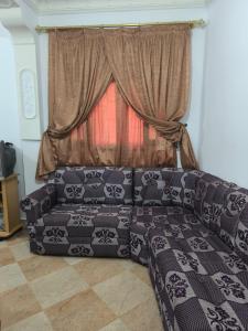 a couch in a living room with a window at nayla y amira in Martil