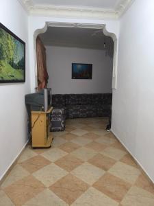 a living room with a tv and a tiled floor at nayla y amira in Martil