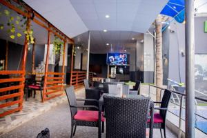 a restaurant with chairs and tables and a tv at Dee Rocket Hotel & Lounge in Ibadan