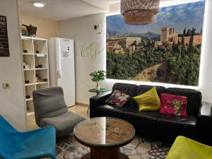 a living room with a black couch and a table at Oh! My Hostel in Granada