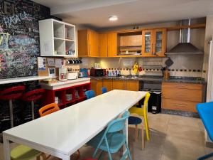 a kitchen with a white table and colorful chairs at Oh! My Hostel in Granada