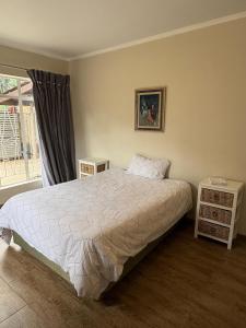 a bedroom with a bed and two night stands at Cornerstone on Livingstone in Vryburg