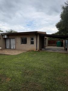 a house with a garage and a grass yard at Cornerstone on Livingstone in Vryburg