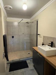 a bathroom with a shower and a sink at Cornerstone on Livingstone in Vryburg +7 photos