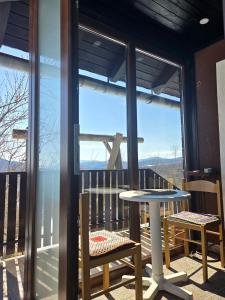 a balcony with a table and chairs and a large window at Cozy Bungalow Stipe in Plitvička Jezera +7 photos