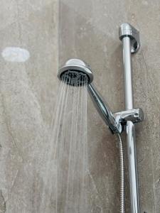 a shower with water coming out of it at AlexBnB in Turin +25 photos