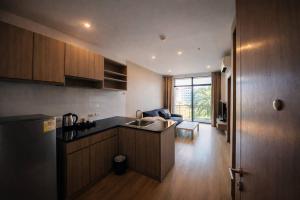 a kitchen with a sink and a living room at Sugar Palm Residence in Phuket