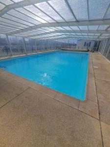a large swimming pool with a roof at Camping Les 2 Plages in Quend