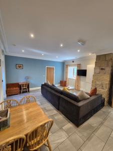 a living room with a couch and a table at Padley Farm in Bradfield