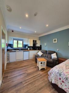 a room with a bed and a kitchen and a couch at Padley Farm in Bradfield