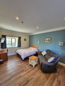 a living room with a couch and a bed at Padley Farm in Bradfield