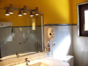 a bathroom with a sink and a shower with a mirror at Hotel Casa Julián in Peñamellera Alta