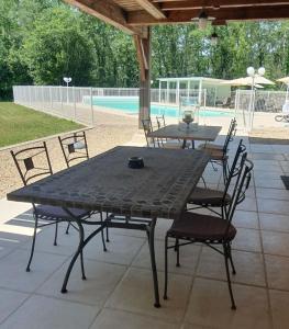 a black table and chairs on a patio at Les Mémis in Brantome en Perigord +17 photos