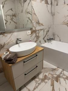 a bathroom with a sink and a mirror and a tub at Nordic Star in Rădăuţi