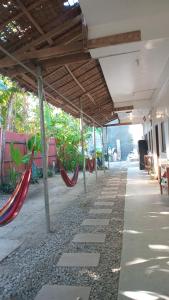 a covered porch with hammocks and plants in a building at Dodong homestay 2 in General Luna