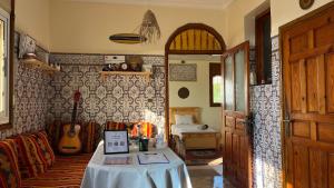 a room with a table and a guitar on the wall at Tidmi Wave Anza in Agadir